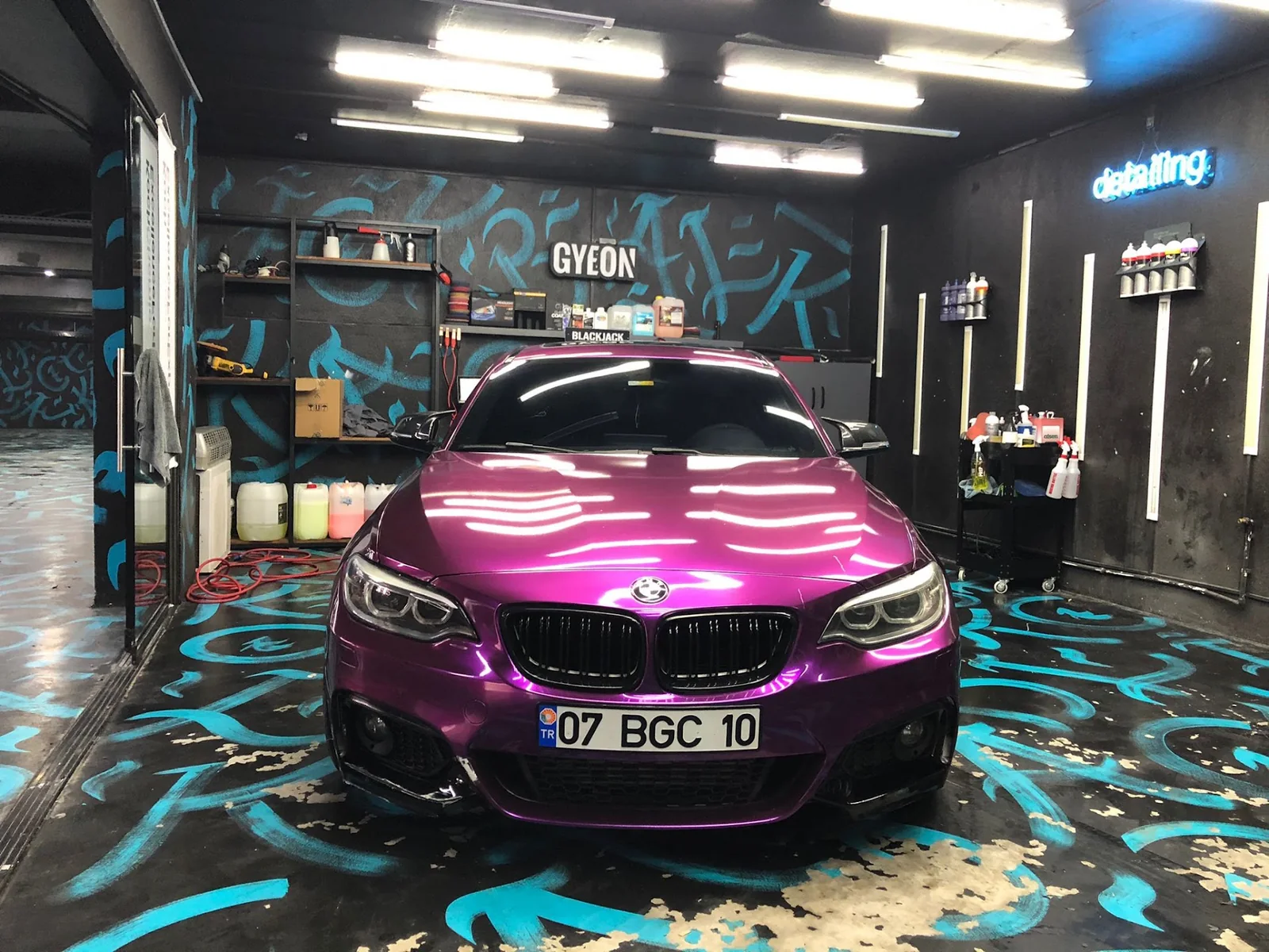 Atölyede metalik mor BMW üzerinde kaput ve ön gövde görünümü